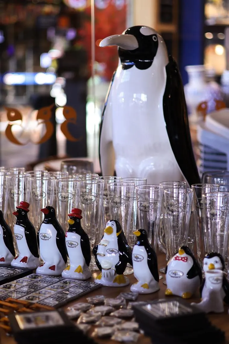Bancada com taças, canecas e os pinguins de porcelana que são marca da casa